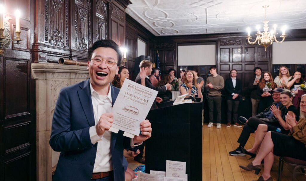 student smiling holding up program